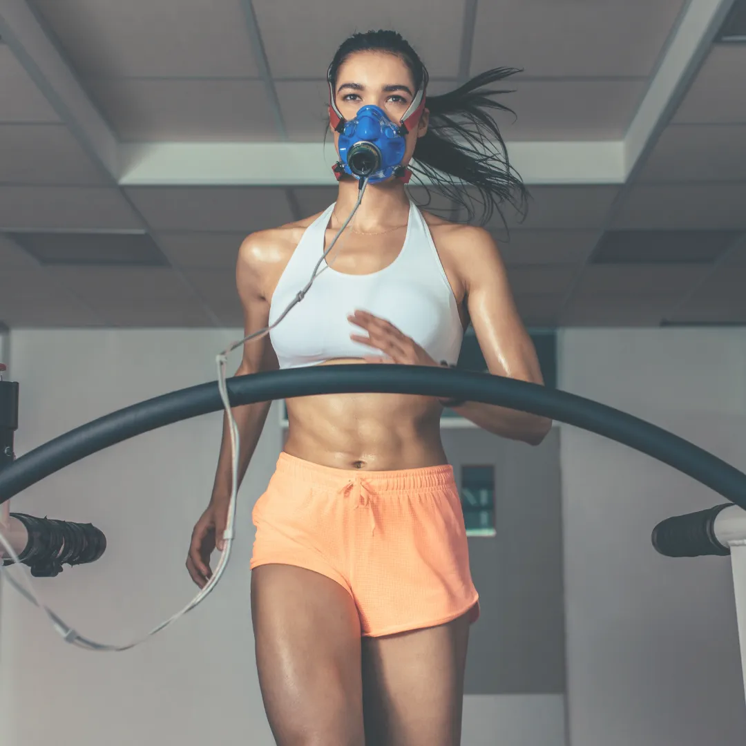 An elite athlete undergoing high-intensity metabolic testing on a treadmill with a VO2 mask, illustrating the physiological demands that require advanced biofield protocols for ATP production and sports recovery.