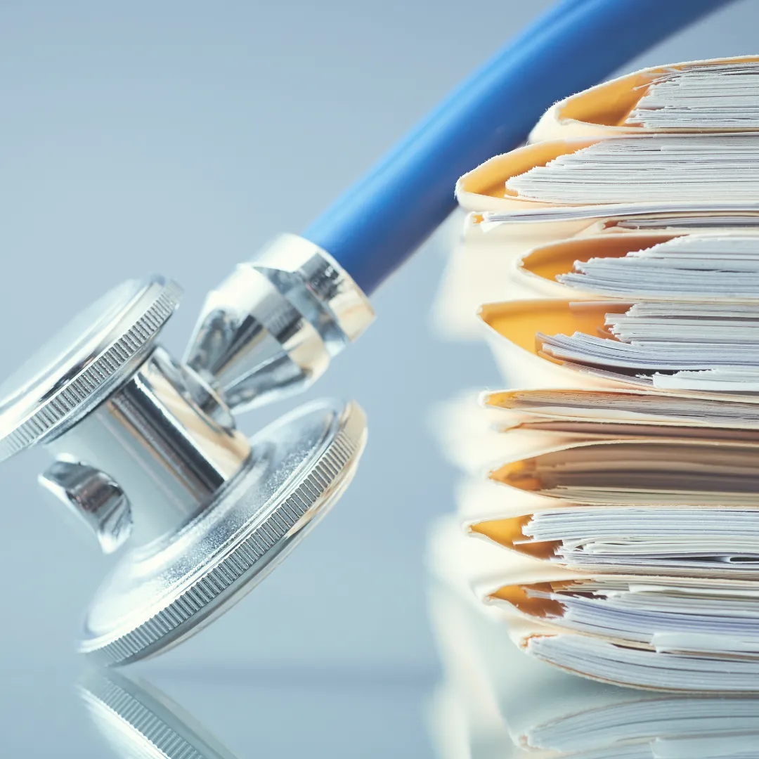 A stethoscope resting on a large stack of patient file folders, depicting the challenge of managing complex, unresponsive cases and the need for expert second opinions.